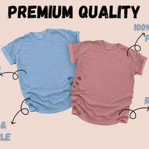 May include: Two short-sleeved t-shirts, one light blue and one dusty rose, are displayed. The shirts have rolled-up sleeves and a relaxed fit. Text on the image reads "Premium Quality", "100% Cotton Fabric", "Printed in USA", and "Soft & Durable".
