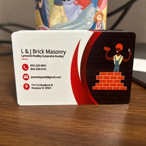May include: A business card for L & J Brick Masonry, featuring the company name, contact information, and a graphic of a bricklayer. The card has a white background with a red curved design and a brick wall illustration.