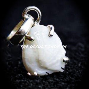 Puede incluir: Un colgante blanco de forma irregular con una fianza plateada. El colgante tiene una superficie texturizada y está suspendido de un anillo plateado. El texto "THE OCCULT SHOP UK" es visible.