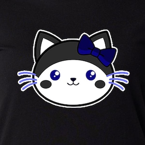 May include: Black t-shirt featuring a cartoon cat face. The cat has a black and white head with a blue bow and blue whiskers. The cat's eyes are blue, and it has pink cheeks. The t-shirt is made of a soft material.