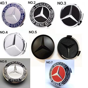 May include: Collection of seven Mercedes-Benz wheel center caps. Designs include silver, black, and red backgrounds with the Mercedes-Benz logo. The caps feature the Mercedes-Benz star emblem and the word "BENZ".