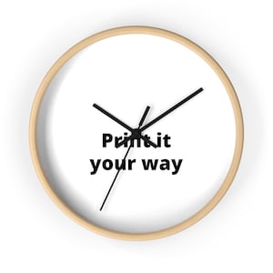 Könnte beinhalten: Runde Wanduhr mit hellem Holzrahmen und weißem Zifferblatt. Die Zeiger sind schwarz, und der Text "Print it your way" ist schwarz auf dem Zifferblatt gedruckt.