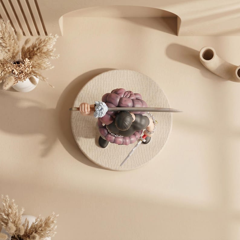 May include: A figurine of a character with a purple brain-shaped head, black clothing, and a sword, positioned on a circular, textured beige surface. The figure is holding a sword and has a chain around its waist. The background is a light beige color.