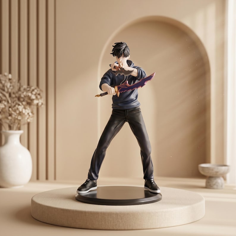 May include: A collectible anime-style figurine of a character with dark hair, wearing a dark blue hoodie and black pants. The figure stands in a combat pose, holding a curved purple and black blade in one hand and a smaller dark dagger in the other.