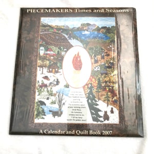 May include: A calendar and quilt book titled "PIECEMAKERS Times and Seasons" with a colorful illustration. The artwork depicts various scenes, including a lake, trees, and cabins. The book is sealed in plastic and includes the text "A Calendar and Quilt Book 2007".