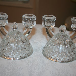 May include: Two clear glass candle holders with a diamond pattern and two candle holders on each.