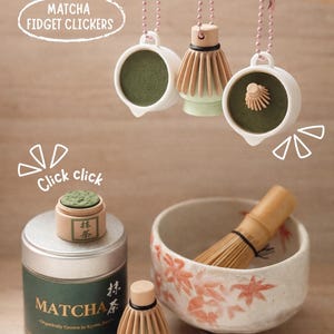 Könnte beinhalten: Ein Bild mit Matcha-Themen-Fidget-Clickern und Zubehör. Das Bild zeigt einen Matcha-Besen, eine Schale mit einem Besen, eine Dose Matcha-Pulver und einen kleinen Matcha-Behälter. Der Text "MATCHA FIDGET CLICKERS" ist sichtbar.