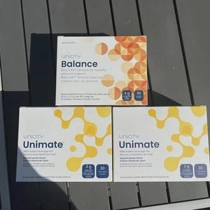 May include: Three rectangular boxes of Unicity dietary supplements. One box is labeled Balance with orange circular patterns, containing 30 packets at 217.5 grams. Two boxes are labeled Unimate with yellow abstract patterns, each containing 30 packets at 153 grams.