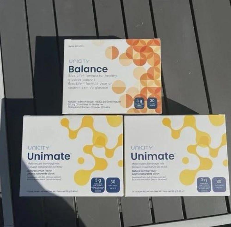 May include: Three rectangular boxes of Unicity dietary supplements. One box is labeled Balance with orange circular patterns, containing 30 packets at 217.5 grams. Two boxes are labeled Unimate with yellow abstract patterns, each containing 30 packets at 153 grams.