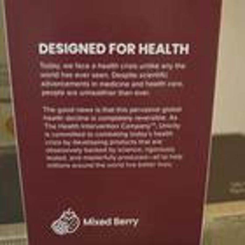 May include: A rectangular maroon product label featuring the white text DESIGNED FOR HEALTH followed by a paragraph about global health and The Health Intervention Company. At the bottom, a white graphic of berries appears next to the text Mixed Berry.