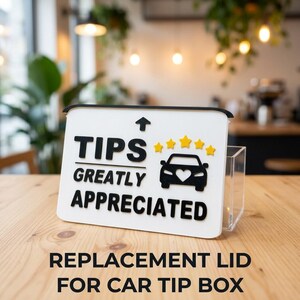 May include: A white rectangular tip box lid featuring black raised text that reads TIPS GREATLY APPRECIATED, an upward arrow, a black car icon with a white heart cutout, and five yellow stars arranged in a horizontal row above the car.