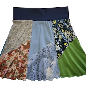 May include: A patchwork skirt with a blue waistband and a variety of floral patterns in shades of blue, green, brown, and white.