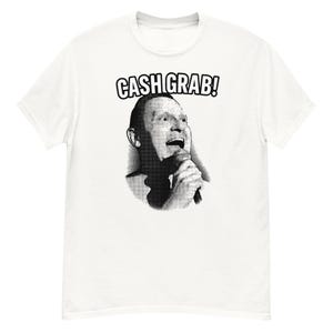 May include: White t-shirt with a black and white graphic of a person holding a microphone and the text "CASH GRAB!". The graphic is a halftone image. The shirt is a short-sleeved, crew neck style.