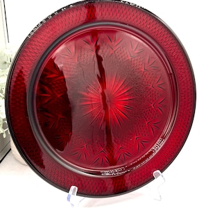 May include: A white ceramic mug with a black handle and the text "But First, Coffee" in a black, handwritten-style font. The mug is on a white surface.