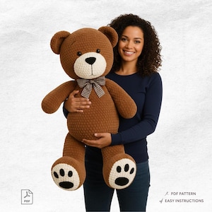 Pode incluir: Um grande urso de pelúcia de crochê marrom com focinho e patas creme, e uma gravata borboleta xadrez. O urso tem olhos pretos e um nariz preto. O urso está sendo segurado por uma pessoa. A imagem também inclui o texto "PDF PATTERN" e "EASY INSTRUCTIONS".