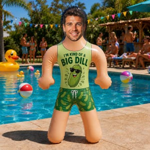 Puede incluir: Un flotador inflable para piscina con una foto personalizada de un rostro sobre un cuerpo de caricatura. La figura viste una camiseta sin mangas verde claro con el texto 'I'M KIND OF A BIG DILL' y un gráfico de pepinillo, junto a un bañador verde con estampado de pepinillos.