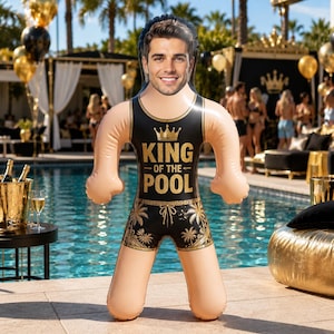 May include: An inflatable pool float shaped like a person with a custom photo face. The figure wears a black tank top and swim trunks with gold palm tree patterns and a crown graphic, featuring the text KING OF THE POOL in bold gold letters.