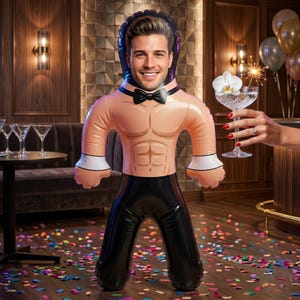 May include: An inflatable party prop featuring a cutout for a face, depicting a muscular torso wearing a black bowtie and white cuffs, paired with black trousers. The design includes a printed image of a smiling person within the head area.