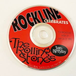 Pode incluir: Um CD vermelho com um centro prateado. O texto "Rockline Celebrates" é impresso em preto sobre fundo vermelho. O texto "The Rolling Stones 30th Birthday" é impresso em preto sobre fundo vermelho. O texto "For Broadcast Week of May 24-31 1993" é impresso em preto sobre fundo vermelho. O texto "Global Satellite Network" é impresso em preto sobre fundo vermelho.