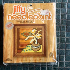 May include: A Jiffy Needlepoint kit featuring a design called "Thistles and Weaving" by Chattore Gemi. The kit includes a printed design on 100% cotton canvas, 100% wool yarn, and complete needlepoint instructions. The design features a vase of yellow flowers with a turquoise and brown patterned background.