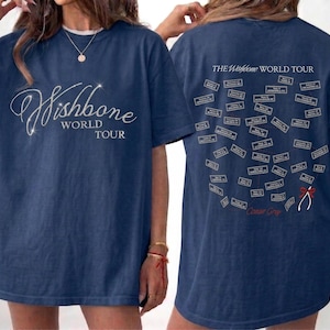 May include: A white ceramic mug with a black handle and the text "But First, Coffee" in a bold, black font. The mug is set against a blurred background, highlighting its clean design.