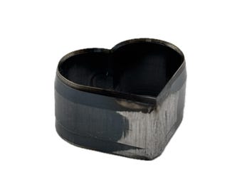 May include: A heart-shaped metal cutting die with a dark, oxidized finish and a sharp, beveled edge. The tool features a hollow center and a sturdy, rigid construction designed for precision cutting of various materials in craft projects.