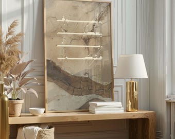 May include: A framed abstract art print with a beige and brown color palette. The artwork features horizontal lines and a textured appearance. A gold-colored lamp with a white lampshade sits on a wooden bench, alongside books and a decorative basket.