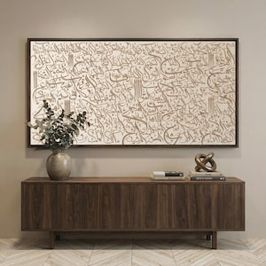 May include: A rectangular wall art piece featuring intricate brown Arabic calligraphy on a cream background, framed in dark wood. The artwork is displayed above a long, dark walnut wooden sideboard with four cabinet doors and a smooth surface.
