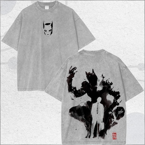 May include: Gray t-shirt with a front graphic of a cat-like face and a back graphic of a dark figure with a person in white. The shirt has a vintage, washed look.