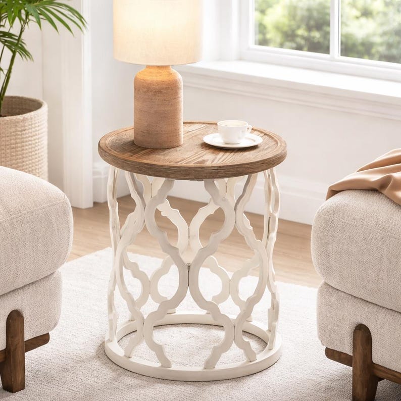 Puede incluir: Una mesa auxiliar redonda con base calada blanca y tapa de madera natural. Una peque&ntilde;a l&aacute;mpara y una taza con platillo est&aacute;n sobre la mesa. La mesa tiene aproximadamente 61 cm de di&aacute;metro y 61 cm de altura.