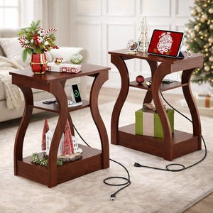 May include: Two dark brown wooden side tables with curved legs. Each table has a top surface, a lower shelf, and a bottom shelf. The tables are decorated with Christmas ornaments, a tablet, and a vase of flowers.