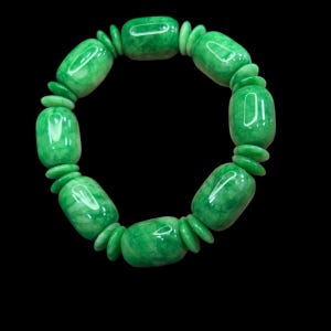 May include: A jade bracelet with a vibrant green hue. The bracelet features large, rounded beads interspersed with smaller, flattened beads. The polished surface of the jade reflects light, creating a glossy appearance. The bracelet is set against a black background.