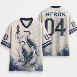May include: A beige V-neck jersey featuring a blue graphic of three herons in a marsh, Japanese calligraphy, and the word HERON with the number 04 on the back. The shirt has short sleeves with blue stripes and the number 0 on the shoulders.