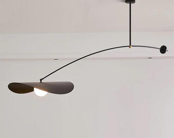 May include: Modern black ceiling light fixture with a curved arm and a flat, petal-shaped shade. The light has a small, round bulb and a minimalist design, perfect for contemporary spaces.