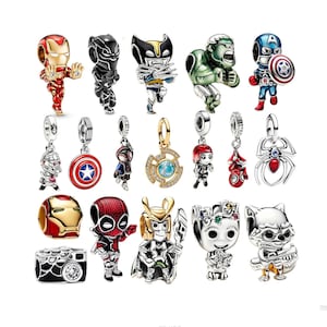 Può includere: Una collezione di ciondoli in metallo raffiguranti vari personaggi di supereroi e simboli, tra cui Iron Man, Black Panther, Wolverine, Hulk, Captain America, Spider-Man, Deadpool, Loki, Groot, Rocket Raccoon e una fotocamera per bracciali.