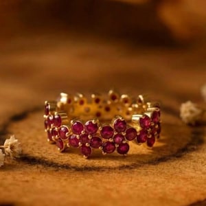 May include: A white ceramic mug with a black handle and the text "But First, Coffee" in a bold, black font. The mug is sitting on a wooden surface. The mug is approximately 4 inches tall.