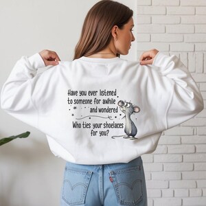May include: White sweatshirt with the text "Have you ever listened to someone for awhile and wondered Who ties your shoelaces for you?" and a cartoon mouse. The sweatshirt is worn by a person wearing blue jeans.