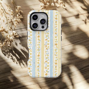 May include: A phone case with a floral pattern in white, yellow, and light blue vertical stripes. The case has a repeating pattern of small yellow flowers and leaves. The case is designed for a smartphone.