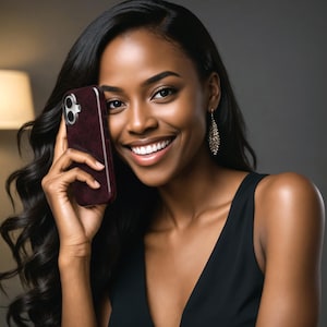May include: A burgundy phone case with a textured pattern. The phone case is held up to the ear. The image features a woman with long, dark hair and a black dress. She is smiling and wearing dangling earrings.
