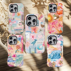 Puede incluir: Cinco fundas de teléfono coloridas con diseños tropicales y de playa. Las fundas presentan imágenes de flores, conchas marinas, olas y los textos "Coastal Life" y "I love you". Las fundas están dispuestas sobre una superficie de madera.