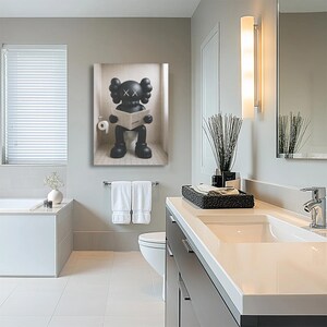 May include: A rectangular wall art print featuring a black cartoon character with X-shaped eyes sitting on a toilet and reading a newspaper. The character has rounded ears and large hands, depicted in a minimalist style against a light background.