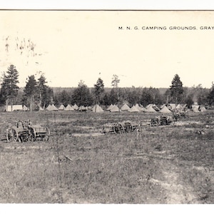 Pode incluir: Postal vintage em preto e branco retratando os M.N.G. Camping Grounds em Grayling, Michigan. A cena mostra um campo com tendas, árvores e carroças puxadas por cavalos. O texto "M. N. G. CAMPING GROUNDS, GRAYLING, MICH." está impresso no topo.