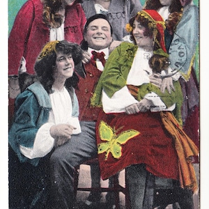 May include: Vintage postcard featuring a group of people in period clothing. The image shows a man surrounded by several women, all smiling. The text at the bottom reads, "Put me amongst the girls!"