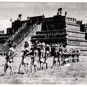 Peut inclure: Carte postale vintage en noir et blanc représentant une procession de personnages en tenue traditionnelle, portant des arcs et des bâtons, devant une grande pyramide à degrés. Le texte en bas indique "Mexico, Priests, Sacerdotes y Guerreros - Teotihuacan, High Priests, Gods and Warriors."