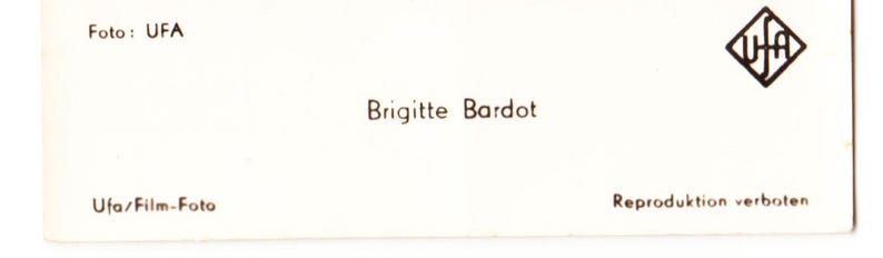 May include: A white ceramic mug with a black handle and the text "But First, Coffee" in a bold, black font. The mug is set against a blurred background, suggesting a cosy setting.