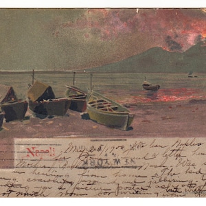Peut inclure: Carte postale vintage représentant une scène côtière avec plusieurs petits bateaux sur le rivage. Un volcan entre en éruption à l'arrière-plan, avec un ciel enflammé. Du texte manuscrit est visible.