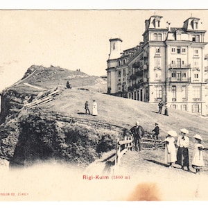 May include: Vintage sepia-toned postcard featuring the Rigi-Kulm (1800 m) in Switzerland. The image shows a large building on a hillside, with people in period clothing. The postcard has text at the bottom.