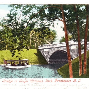 Peut inclure: Carte postale ancienne représentant un pont en pierre au-dessus d'une rivière dans le parc Roger Williams, Providence, RI. Un petit bateau avec des passagers flotte sur l'eau. Des arbres et de l'herbe verte entourent le pont et la rivière.