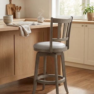 May include: A gray swivel bar stool with a light gray padded seat and a slatted back. The stool has a footrest and is made of wood. The stool is in a kitchen setting with a wooden countertop and cabinets.