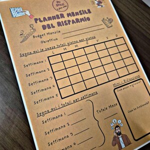 May include: A tan-colored monthly budget planner with black text and illustrations. The planner includes sections for tracking expenses, setting goals, and reflecting on the month. The text includes "PLANNER MENSILE DEL RISPARMIO".